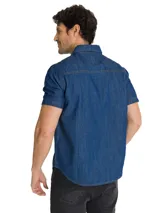 Camisa de jean de manga corta, color azul, con cierre frontal de botones, cuello camisero y bolsillo en el pecho con etiqueta de la marca.