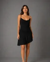 Vestido corto negro de breteles finos, con escote drapeado y falda de caída fluida con diseño asimétrico.