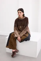 Sweater de punto con diseño en bloques de tonos marrones y tostados, cuello redondo y mangas largas amplias.