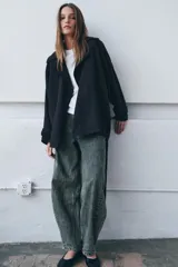 Trench corto de Zara, confeccionado en mezcla de lyocell, color verde militar. Presenta cuello solapa, manga larga con hombro caído y puños con trabilla. Incluye bolsillos delanteros de plastrón, cierre frontal cruzado con botón y cinturón de lazada en el mismo tejido.