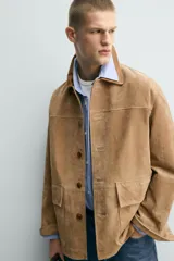 Chaqueta relaxed fit de piel con acabado serraje en color tostado, con cuello de solapa combinado a contraste, bolsillos de plastrón con solapa en la cadera y cierre frontal de botonadura.