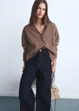 Pantalón de jean tiro alto con corte culotte y pernera ancha. Presenta cierre frontal con cremallera y botón, trabillas para cinturón, bolsillos traseros y bajo con acabado deshilachado.