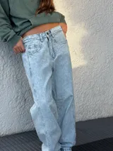 Pantalón de jean celeste con lavado ácido, corte amplio y tiro alto.