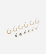 Set de seis pares de aros dorados, tres pares de argollas de diferentes tamaños y tres pares de aros tipo botón con resina de colores.