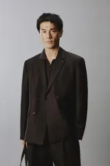 Blazer cruzada de hombre en color marrón oscuro, de corte regular fit, confeccionada en lino. Cuenta con solapas de muesca, bolsillos con solapa en la cadera y doble botonadura frontal.