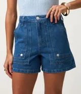 Short mom de tiro alto confeccionado en denim de algodón, con diseño de bolsillos tipo carpintero en el frente y bolsillos traseros. Presenta trabillas en la cintura y cierre tradicional.