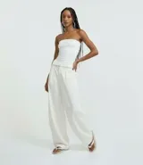 Blusa blanca sin breteles, confeccionada en microfibra, con detalle de encaje en el lateral y corte ajustado.