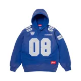 Hoodie Supreme de algodón en color azul, con diseño inspirado en camisetas de fútbol americano. Presenta el número 08 en el frente y hombros, parches bordados con logotipos y detalles deportivos, capucha con cordones ajustables y bolsillo tipo canguro.