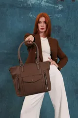 Cartera tipo tote de diseño estructurado en símil cuero, con doble asa rígida y correa regulable. Presenta múltiples bolsillos frontales con cierre y solapa, ofreciendo un estilo versátil y espacioso.