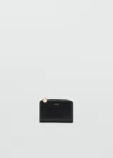 Billetera pequeña de poliuretano efecto piel en color negro, con cierre de solapa con botón a presión, seis ranuras para tarjetas y bolsillo lateral con cierre de cremallera. Incluye detalles metálicos dorados y el logo de la marca estampado en el frente.