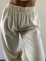 Pantalón de lino color manteca, de corte holgado con cintura elástica y puños elásticos en los tobillos. Cuenta con bolsillos laterales.