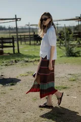 Pollera midi tejida en hilado 100% algodón, color marrón con rayas horizontales en tonos rojo y verde.