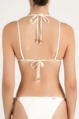 Top de bikini triangular color crema, con doble bretel regulable y detalles metálicos dorados en el centro y los tirantes.