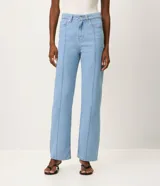 Pantalón recto de jean color azul oscuro, tiro alto, con costuras aparentes en contraste, trabillas en la cintura, cierre tradicional y bolsillos.