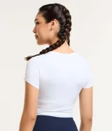 Remera deportiva tipo crop top de color negro, con cuello redondo y mangas cortas. Confeccionada en tejido de malla suave y elástico.