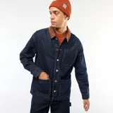 Chaqueta de denim azul oscuro con cuello de pana en color marrón, cierre frontal con botones metálicos, bolsillos frontales tipo parche y costuras a contraste.