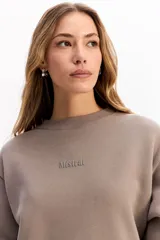 Buzo de algodón color crema, con cuello redondo, mangas largas y calce relajado. Presenta el logo de la marca bordado en el centro del pecho.