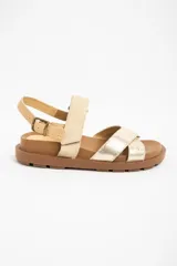 Sandalias planas de cuero en color camel y dorado, con suela track marrón y tiras cruzadas en la parte delantera. Cuentan con tira ajustable en el talón con hebilla metálica.