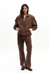 Pantalón de cuero de oveja color marrón antiguo, de corte recto, tiro medio, con elástico interno en la cintura y tajos en el ruedo.