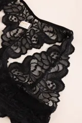 Soutien tipo bralette negro de encaje con diseño floral, espalda estilo nadador y elástico en el bajo busto para sujeción.
