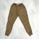 Pantalón cargo color camel de corte relajado, con cintura elástica fruncida, bolsillos laterales en las piernas y puños elásticos en los tobillos.