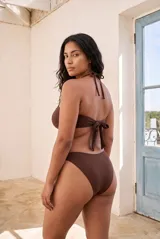 Conjunto de bikini color blanco marfil con corpiño tipo banda con tirante halter y bombacha de corte clásico.