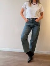 Jeans mom fit de tiro alto y pierna relajada, en tono denim envejecido con matices gris-azulados. Presenta un diseño exclusivo con efecto de pinceladas y salpicaduras artísticas, bolsillos delanteros y traseros, y costuras reforzadas.