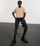 Remera cropped de manga corta, cuello redondo y calce oversized, confeccionada en tejido de algodón tipo media malla.