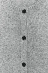 Chaleco de punto suave con cuello redondo, diseño sin mangas y cierre frontal con botones. Presenta terminaciones en rib en el cuello, sisas y ruedo.