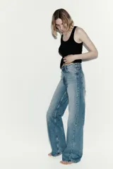 Pantalón de jean con diseño wide leg, de tiro alto y cinco bolsillos, en tono azul desgastado.