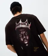 Remera de algodón con cuello redondo y mangas cortas. Presenta una estampa en la espalda que muestra el rostro de The Notorious B.I.G. con una corona, junto con una firma en la parte inferior.