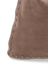 Cartera de hombro de gamuza marrón, estilo hobo, decorada con tachas metálicas en los bordes y las asas.