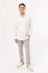 Camisa de manga larga blanca, corte slim fit, con cuello clásico y botones frontales.