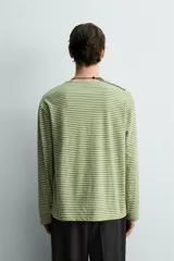 Camiseta de manga larga con ajuste relaxed fit y cuello redondo amplio, confeccionada en tejido de mezcla de algodón y lino con patrón de rayas horizontales en color verde y blanco.