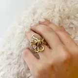 Anillo de bronce color dorado con forma de panal de abeja y una abeja en el centro.