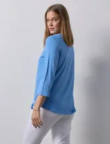 Remera blanca de modal con cuello cuadrado y aplique de aros metálicos.