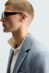 Blazer de corte slim fit confeccionada en tejido con lana, con cuello de solapas de muesca, cierre frontal de un botón, bolsillos laterales con solapa y bolsillo de vivo en el pecho.