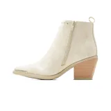 Bota corta de vestir Korium Inari color blanco marfil con detalles plateados en forma de rayo, tachas decorativas, puntera metálica y taco cuadrado de madera.