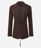 Blazer sastre color marrón, de corte alargado y ligeramente entallado. Presenta cuello solapa clásico, cierre frontal con un solo botón y forro interno. Las mangas son largas y en la espalda tiene un recorte central con tiras ajustables entrelazadas para un lazo personalizado.