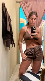 Conjunto de bikini marrón con corpiño triangular y short con cordones y flecos.