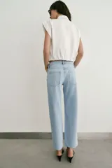 Jeans Z1975 de tiro alto y corte slim, color azul con lavado medio, diseño de cinco bolsillos y bajo sin costuras. Cierre frontal con cremallera y botón metálico.