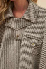 Poncho de lana fina con diseño de rayas diagonales, cuello camisero, cartera con botones a presión y bolsillo ojal en el pecho.