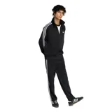 Campera deportiva Adidas modelo Firebird, color negro con las icónicas tres tiras blancas en las mangas y logo del trébol bordado en el pecho. Presenta cuello alto, cierre frontal completo y puños acanalados.