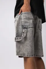 Bermuda de jean de corte mom, estilo carpintero, con lavado ácido gris claro. Presenta costuras marcadas, bolsillos funcionales y detalles de refuerzo en los laterales.