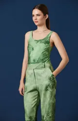 Body de mujer con escote redondo, sin mangas y corte de pierna clásico. Presenta un estampado artístico de paisaje en tonos suaves sobre fondo claro.