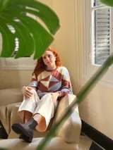 Sweater de punto con diseño geométrico en tonos celeste, marrón y beige.