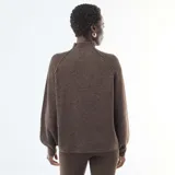 Sweater de punto canalé en color marrón, con cuello alto y mangas largas con puños ajustados. Presenta un diseño de corte holgado y tejido texturizado.