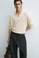 Polo de punto color crema con cuello solapa y abertura frontal, manga larga y diseño de trenzas.