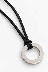 Collar largo con cordón de cuero negro regulable y dije circular metálico plateado.