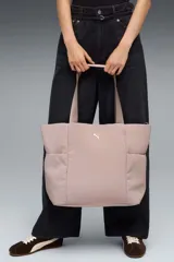 Bolso tipo shopper Puma Up de color negro, con asas de hombro y el logo de la marca en dorado en la parte frontal.